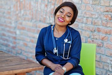 african-caregiver-female-with-stethoscope-posed-outdoor.