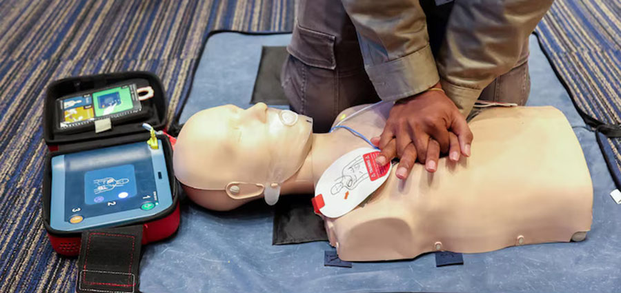 high-angle-view-of-a-male-health-instructor-showing-how to-administer-CPR-to-a-dummy.