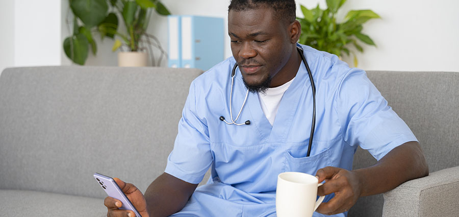 male ceregiver using a phone. Explore caregiver jobs abroad.