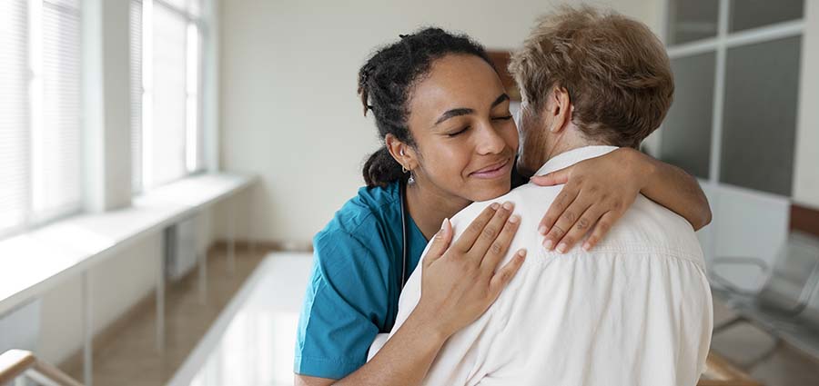 passionate caregiver woman hugging an elderly patient. Offering emotional support.