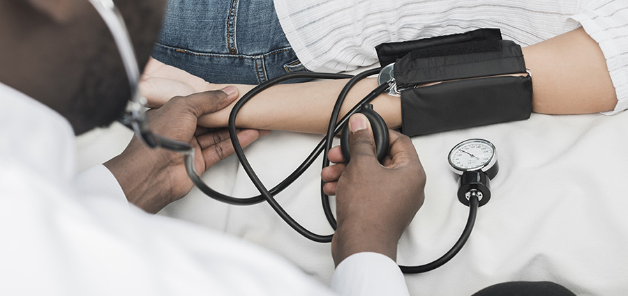 cetified-nursing-assistant-taking-blood-pressure-readings-from-a-patient. CNA course vs caregiver training in Kenya.