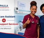 Two-smiling-kenyan-female-nurses-gesturing-thumbs-up-in-hospital-room-in-different-uniforms. Healthcare Assistant vs Health Support Services.